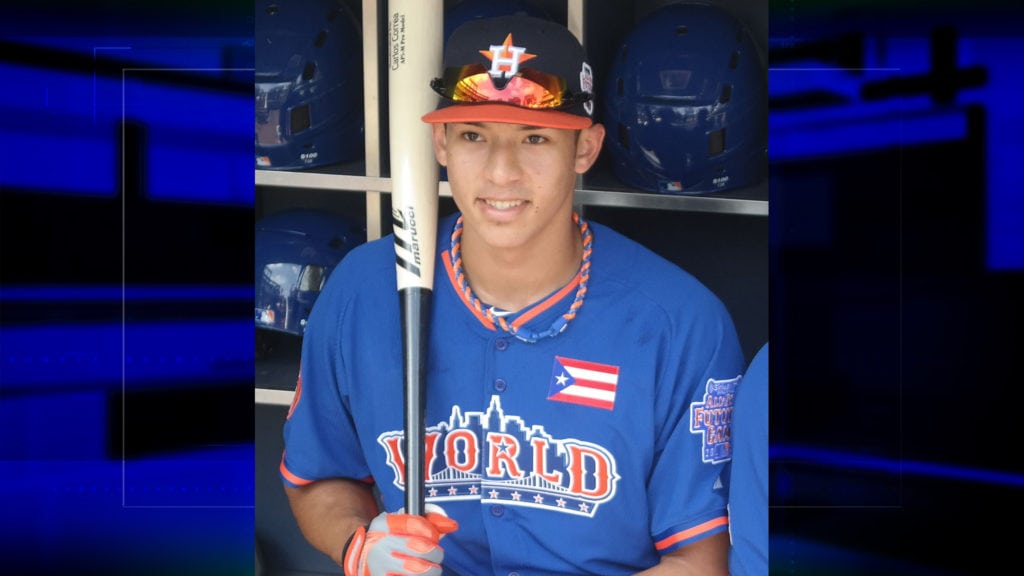 Carlos Correa holding bat in dugout